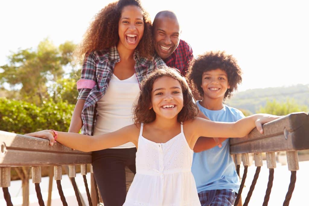 Portrait Of Family On Playground Climbing Frame